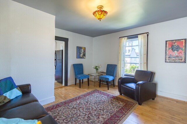 living area featuring hardwood / wood-style floors and baseboards