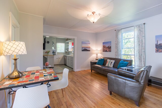 living area with baseboards and light wood finished floors