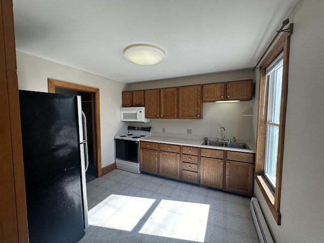 kitchen with white appliances, sink, and a baseboard heating unit