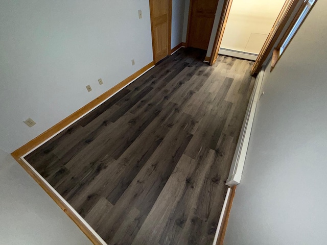 interior space featuring dark hardwood / wood-style flooring, a closet, and a baseboard heating unit