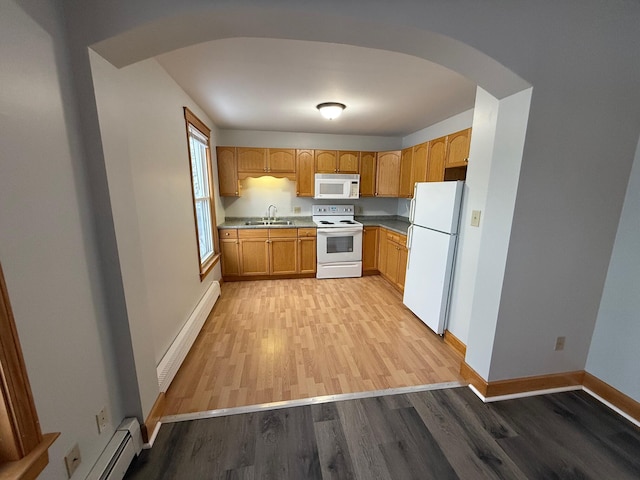 kitchen with white appliances, light wood-type flooring, sink, and a baseboard heating unit