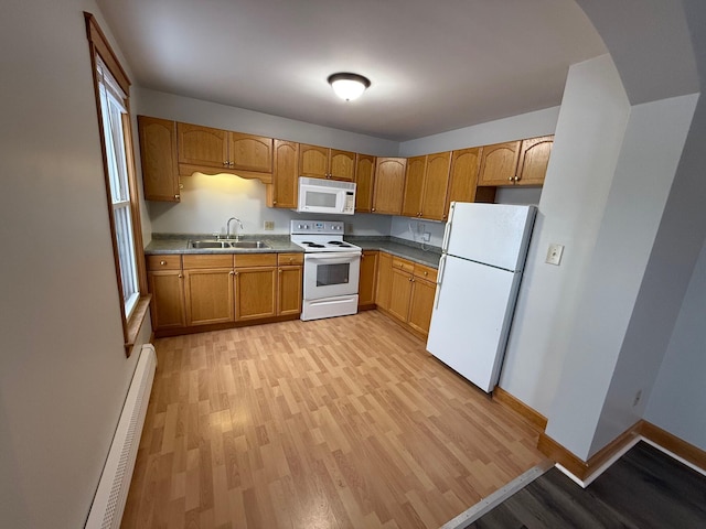 kitchen with white appliances, light hardwood / wood-style floors, a wealth of natural light, sink, and a baseboard radiator