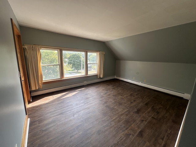 additional living space featuring lofted ceiling, baseboard heating, and dark wood-type flooring