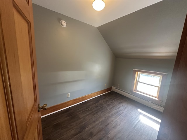 bonus room featuring a baseboard heating unit, vaulted ceiling, and dark wood-type flooring