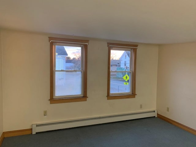 carpeted spare room featuring a baseboard radiator