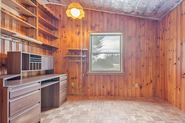 kitchen with wooden walls and light parquet floors