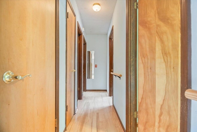 hallway featuring a textured ceiling and light wood-type flooring