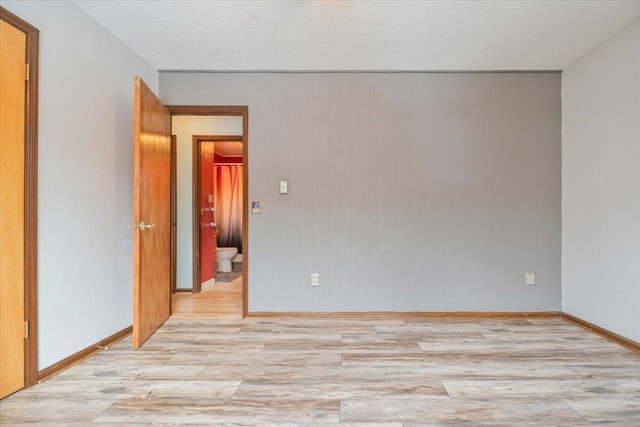 empty room featuring a textured ceiling and light hardwood / wood-style floors