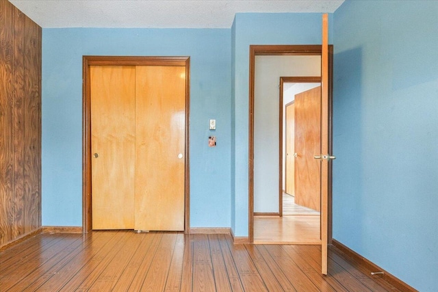 unfurnished bedroom with a textured ceiling and light wood-type flooring