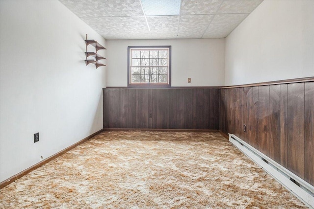 carpeted spare room featuring a baseboard heating unit