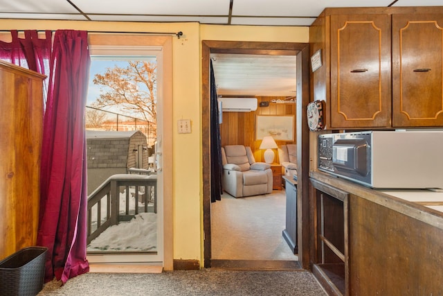 entryway with a wall mounted air conditioner, carpet floors, and a drop ceiling