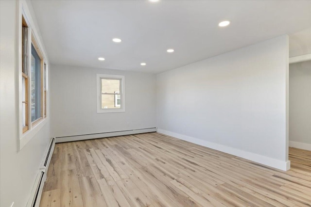 spare room featuring light wood-type flooring and a baseboard heating unit