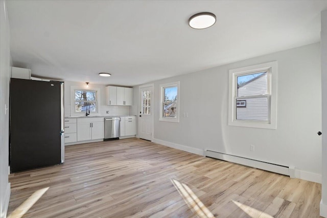 kitchen featuring white cabinetry, backsplash, a baseboard radiator, plenty of natural light, and appliances with stainless steel finishes