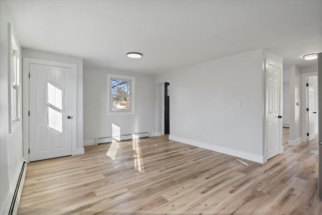 foyer entrance with light hardwood / wood-style floors and a baseboard heating unit