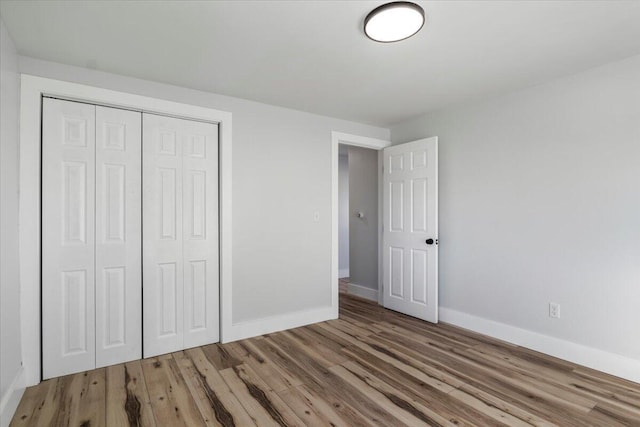 unfurnished bedroom with a closet and hardwood / wood-style flooring