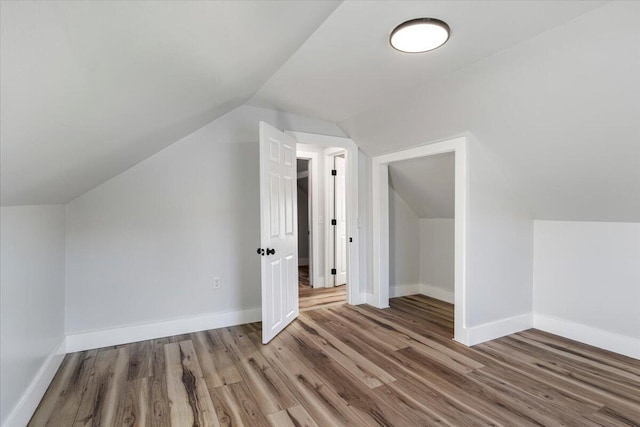 bonus room with hardwood / wood-style flooring and vaulted ceiling