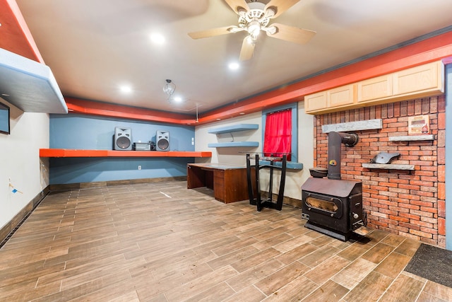 interior space with ceiling fan and a wood stove