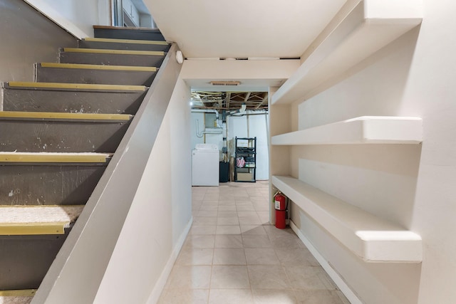 stairs with washer / clothes dryer and tile patterned floors