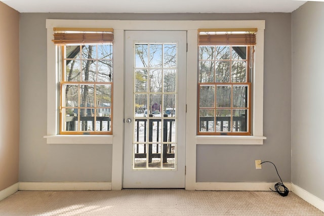 doorway to outside featuring a healthy amount of sunlight and carpet floors