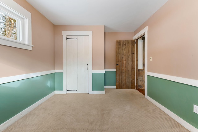 unfurnished bedroom featuring a closet and light carpet