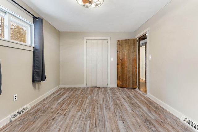 unfurnished bedroom with a closet and light hardwood / wood-style floors