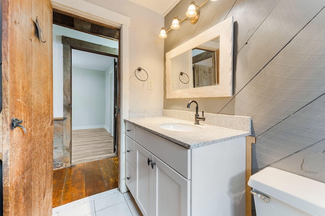 bathroom with tile patterned flooring, vanity, and toilet