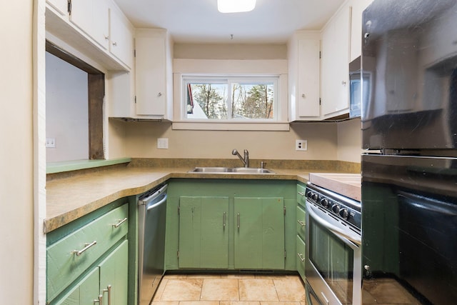 kitchen featuring stainless steel appliances, green cabinetry, sink, white cabinetry, and light tile patterned flooring