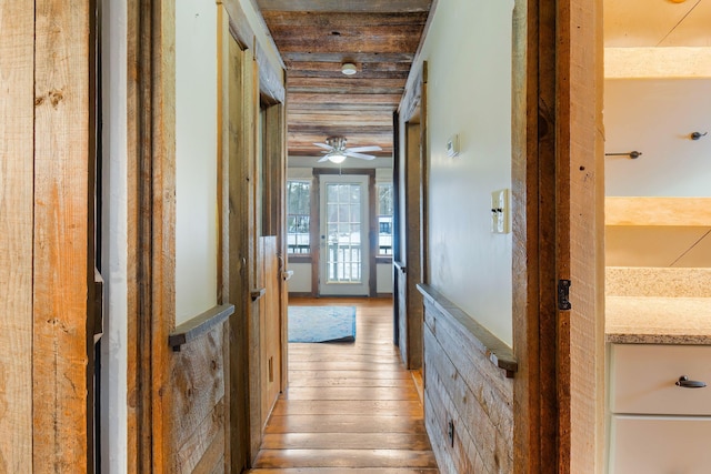 hallway featuring light wood-type flooring and wood ceiling