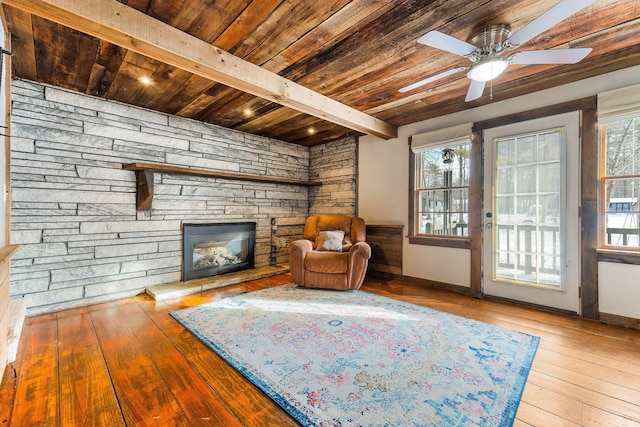 sitting room featuring wood ceiling, light hardwood / wood-style floors, beamed ceiling, ceiling fan, and a fireplace