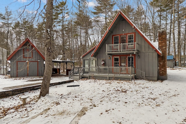 view of front of home featuring a balcony, a garage, and an outbuilding