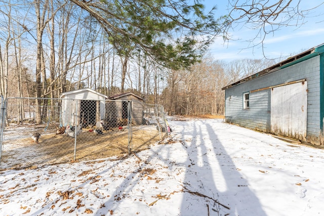 yard layered in snow featuring an outdoor structure