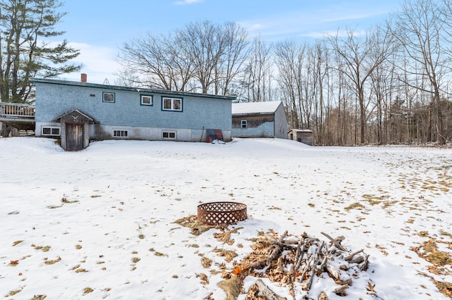 snow covered property featuring an outdoor fire pit