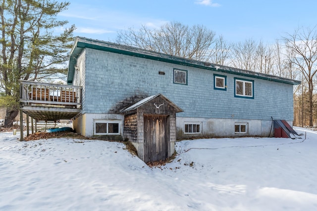 snow covered house featuring a deck