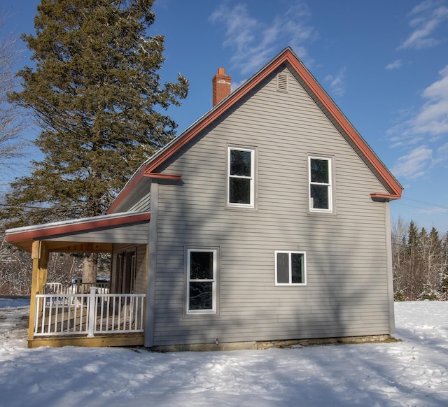 snow covered property featuring covered porch