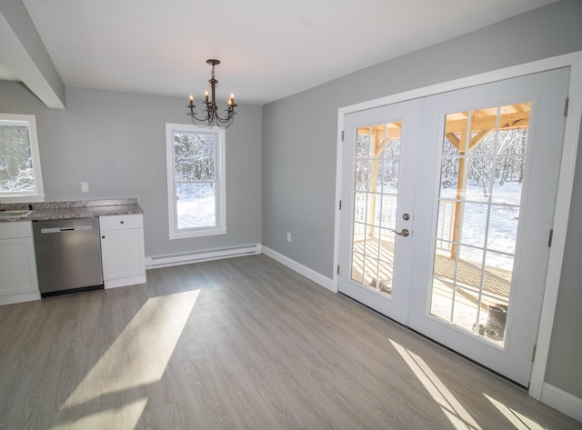 kitchen featuring white cabinetry, a notable chandelier, decorative light fixtures, a baseboard radiator, and dishwasher