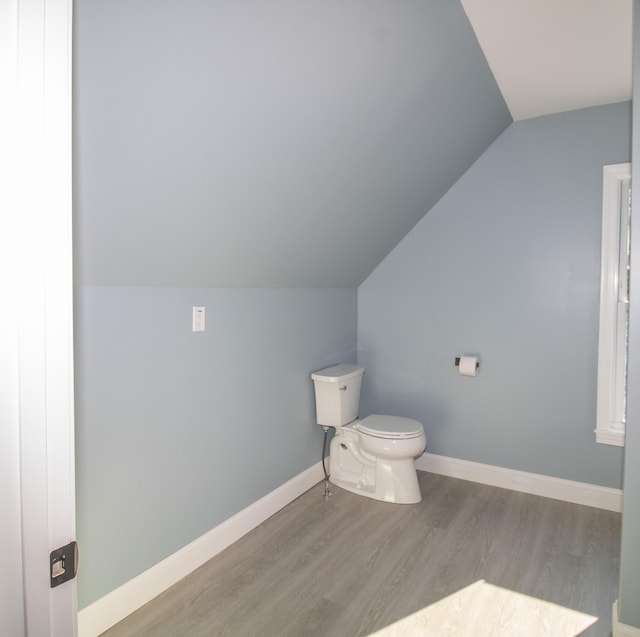 bathroom featuring lofted ceiling, wood-type flooring, and toilet