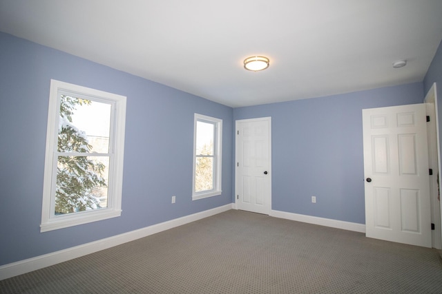 unfurnished room featuring dark colored carpet