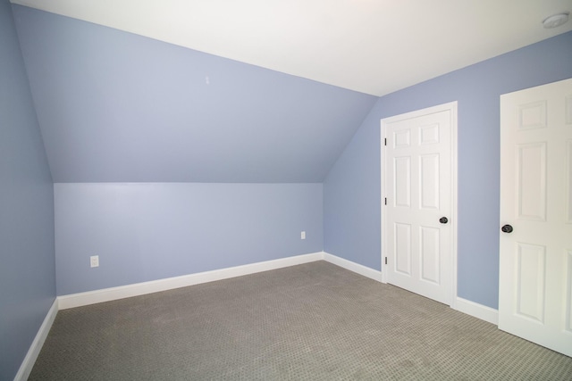 additional living space with lofted ceiling and carpet flooring