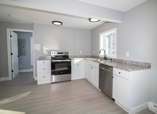 kitchen with white cabinets, sink, stainless steel appliances, and light hardwood / wood-style flooring