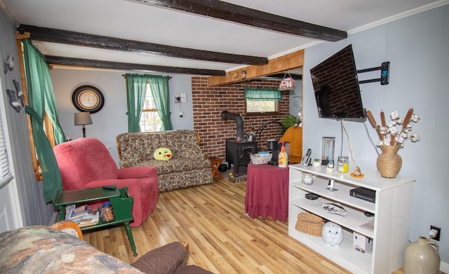 living room featuring brick wall, light hardwood / wood-style flooring, a wood stove, and beamed ceiling