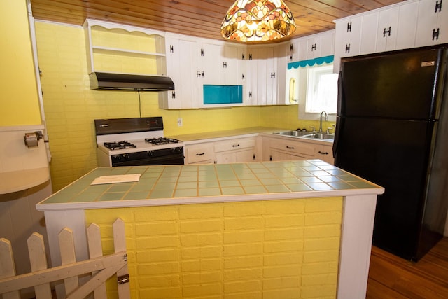 20 Cottage St, Milbridge, ME 04658 - kitchen featuring white gas range oven, a sink, freestanding refrigerator, tile countertops, and under cabinet range hood