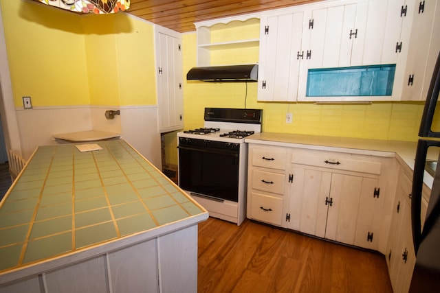 20 Cottage St, Milbridge, ME 04658 - kitchen with open shelves, ventilation hood, tile countertops, wood finished floors, and gas range