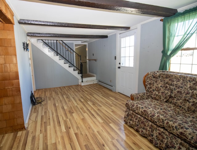20 Cottage St, Milbridge, ME 04658 - living area with wood walls, a baseboard radiator, beamed ceiling, light wood finished floors, and stairs