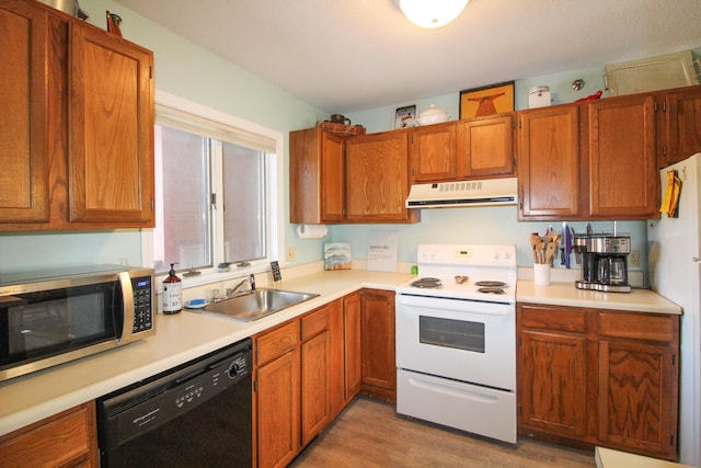 kitchen featuring light wood-style flooring, white appliances, a sink, light countertops, and ventilation hood