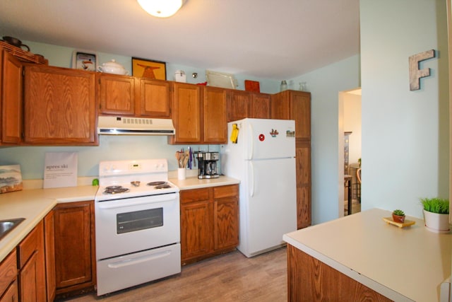 kitchen featuring light wood finished floors, light countertops, brown cabinetry, white appliances, and under cabinet range hood