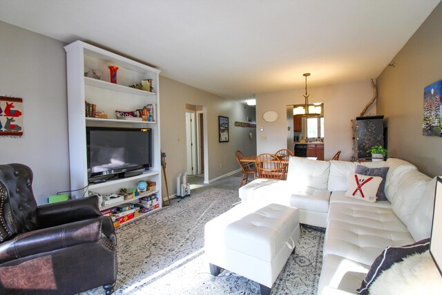 living area with baseboards and an inviting chandelier