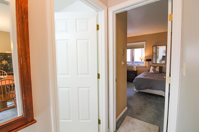 corridor with carpet flooring and baseboards