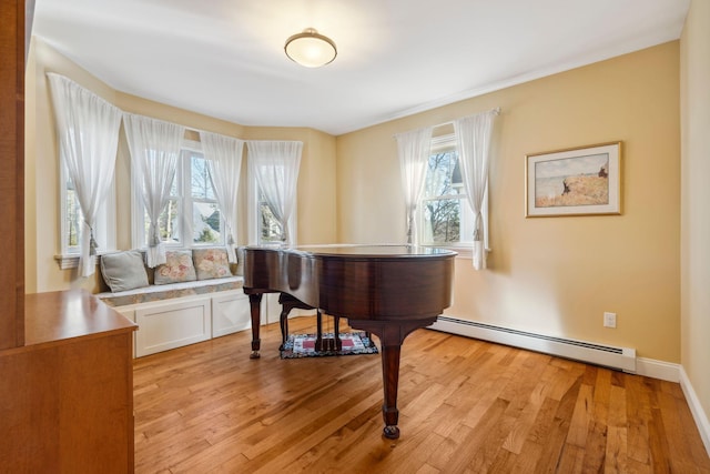 miscellaneous room with a baseboard heating unit and light hardwood / wood-style floors