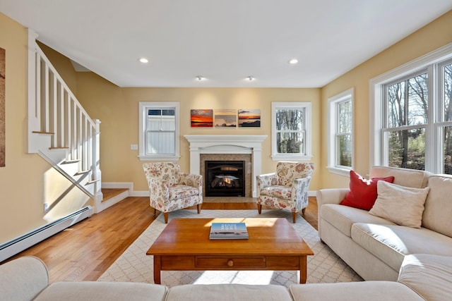 living room featuring a baseboard heating unit and light wood-type flooring