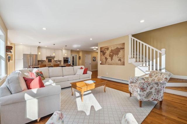 living room featuring a baseboard heating unit and light hardwood / wood-style floors